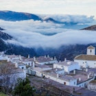 The village of Bubión hovering above the early morning clouds © Brendan Sainsbury / Lonely Planet