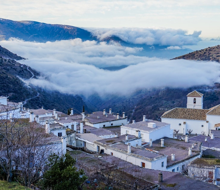 The village of Bubión hovering above the early morning clouds © Brendan Sainsbury / Lonely Planet