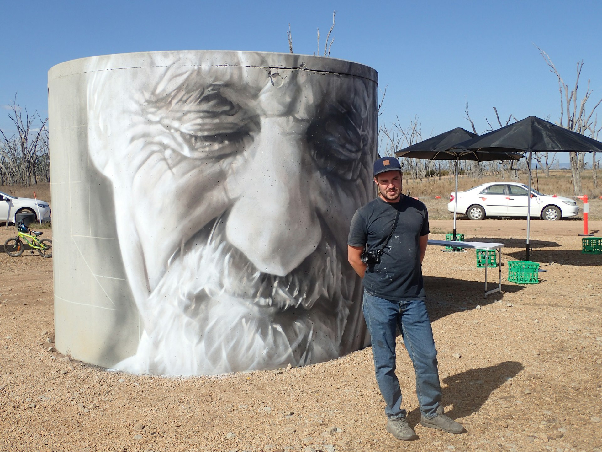 Artist Guido van Helten stands in front of his art in the Winton Wetlands near Benalla. © Tim Richards / Lonely Planet