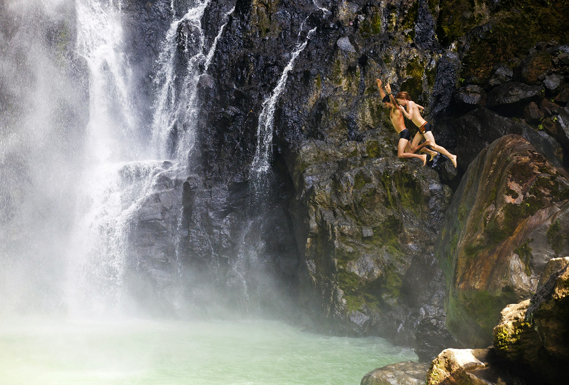 Two people jump into the pool at the foot of Victoria Falls © Nick Ledger / Getty Images