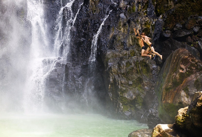Features - Dominica, Delices. Two people jump into the plunge pool at the foot of Victoria Fals.