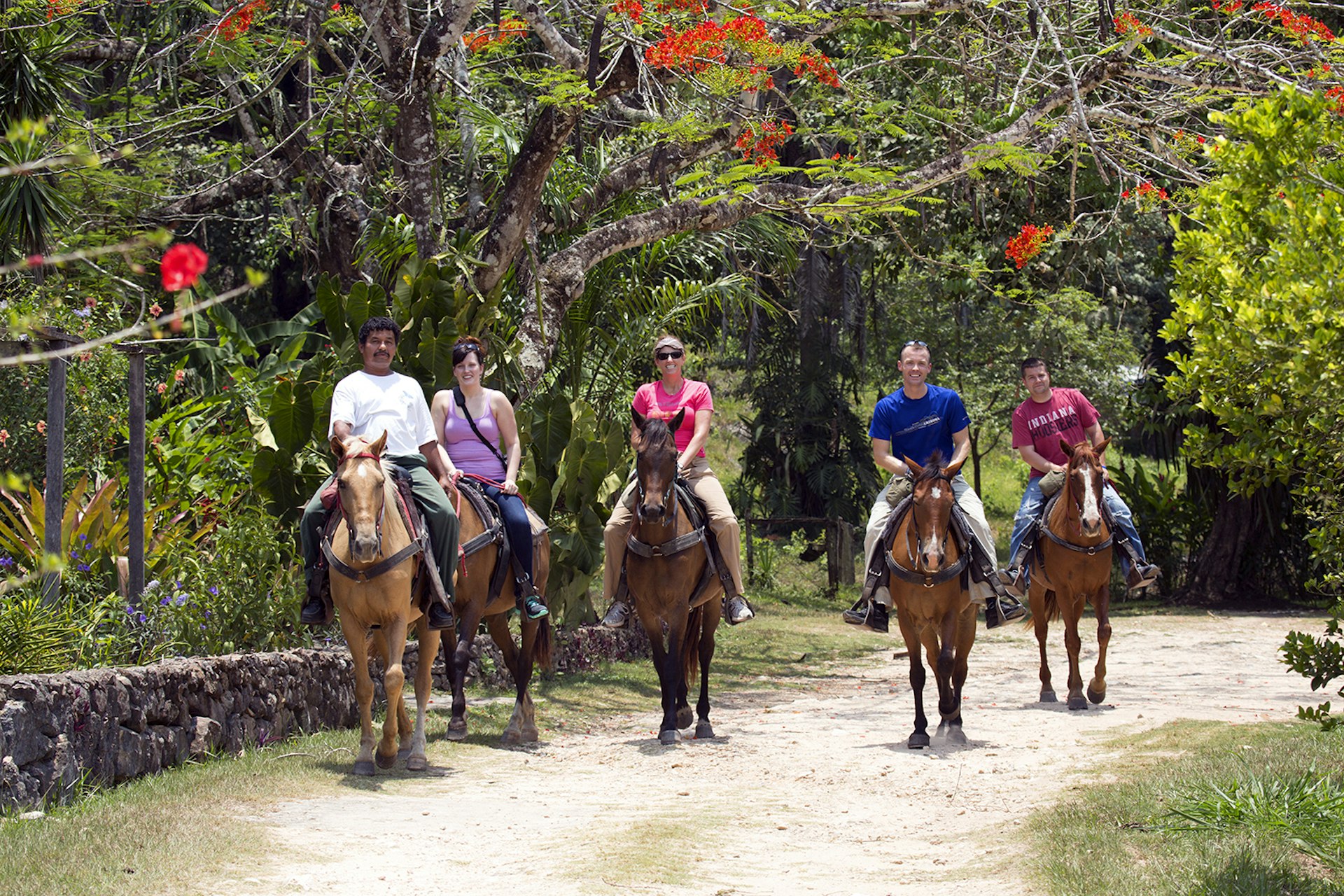 Central America, Belize, Mountain Pine Ridge, tourists and guide on horseback at Mountain Equestrian Trails © Alex Robinson / Getty Images