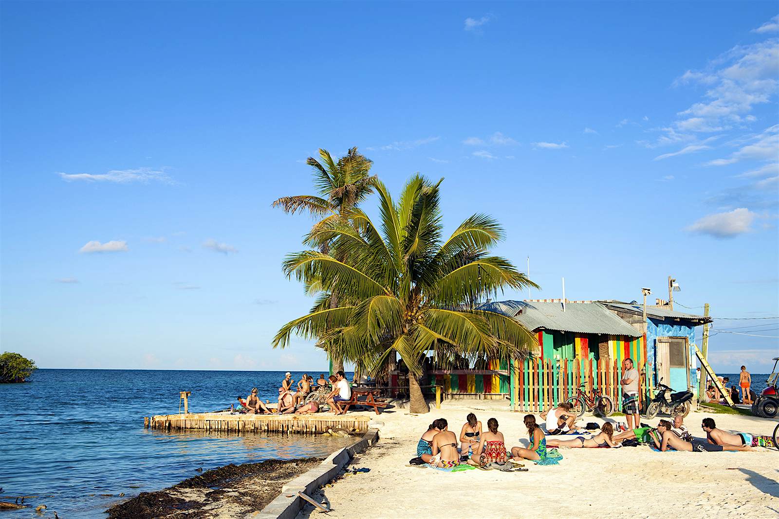 People sit on the small beach outside the Lazy Lizard bar © Alex Robinson / Getty Images