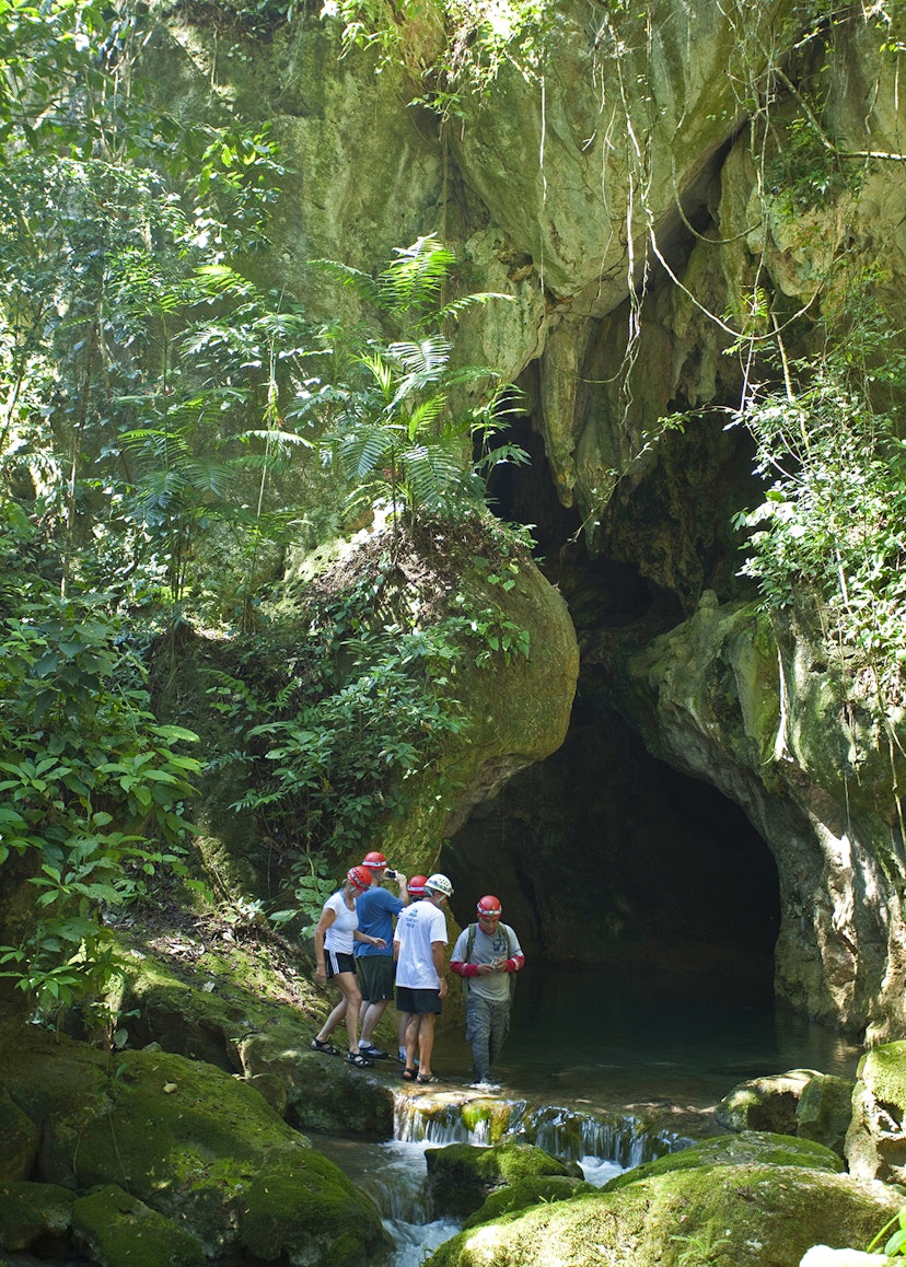 Features - Central America, Belize, Cayo, a guide escorts tourists into the Actun Tunichil Muknal (ATM) cave near Belmopan