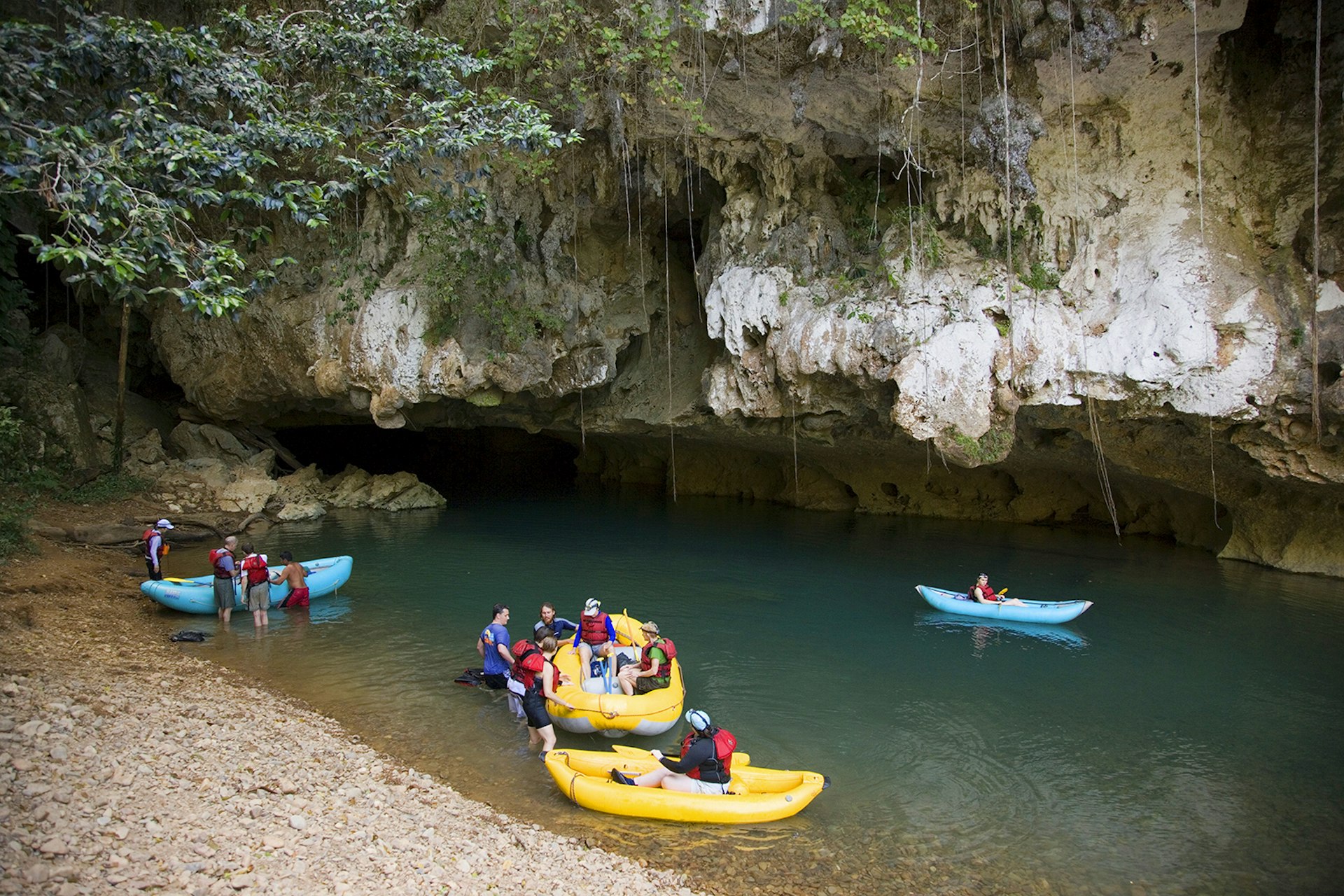 A group of adventure tourists traversing four caves by raft and kayak on Caves Branch River © Henri Georgi / Getty Images