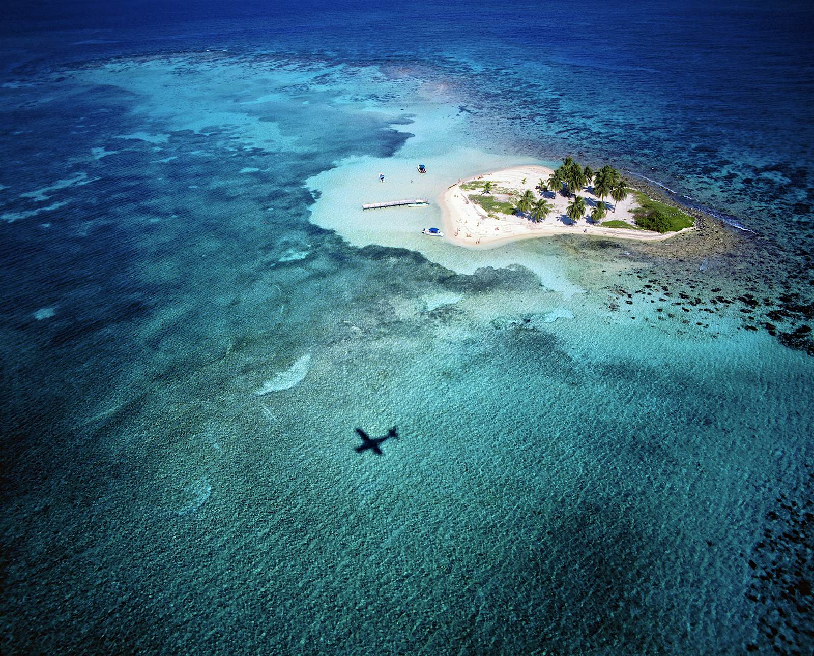 A plane flies over Goff's Caye Island in Belize © Slow Images / Getty Images