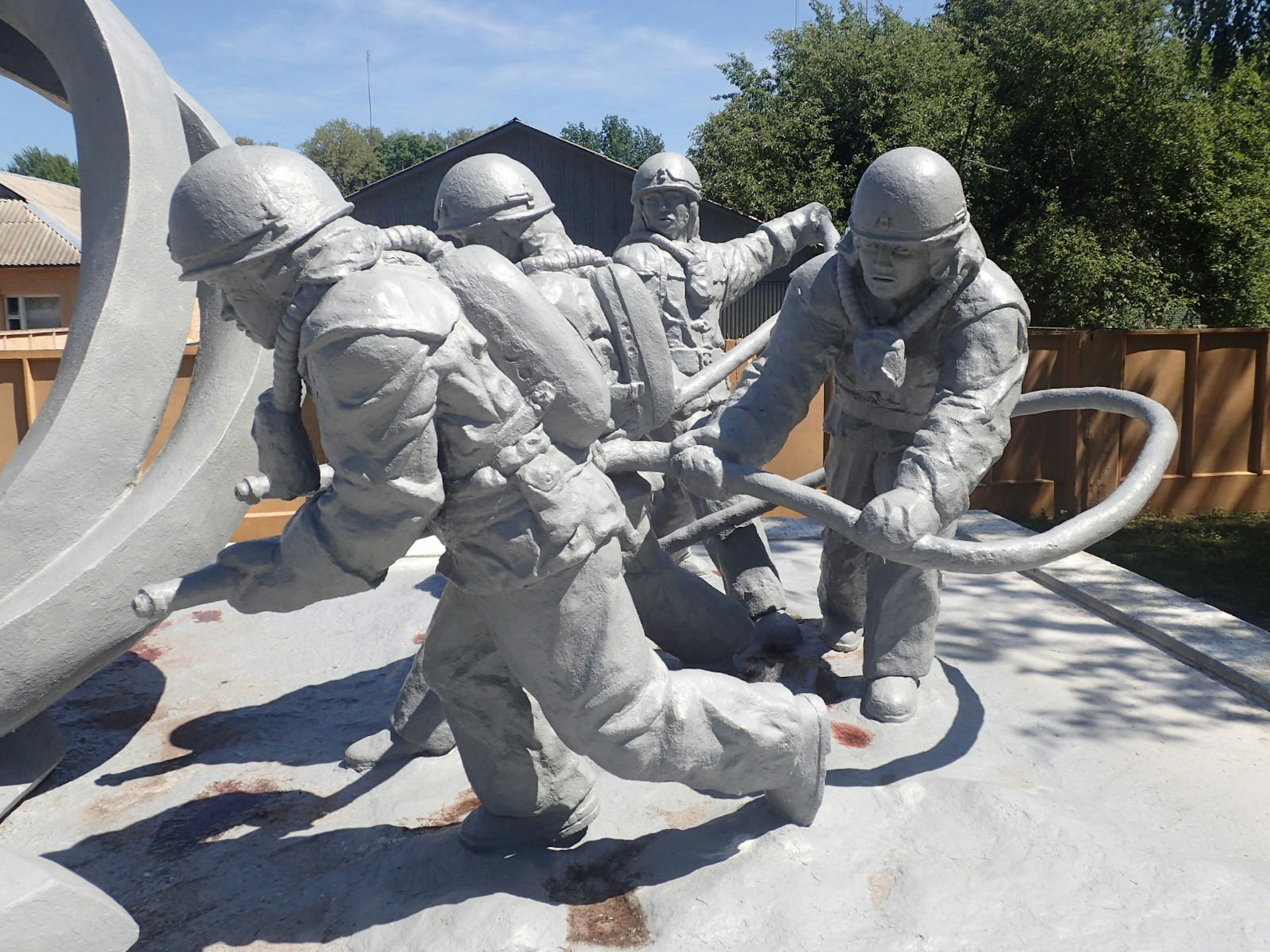 Monument to emergency workers outside Chernobyl, with concrete sculptures of firefighters with hoses tackling the explosion.