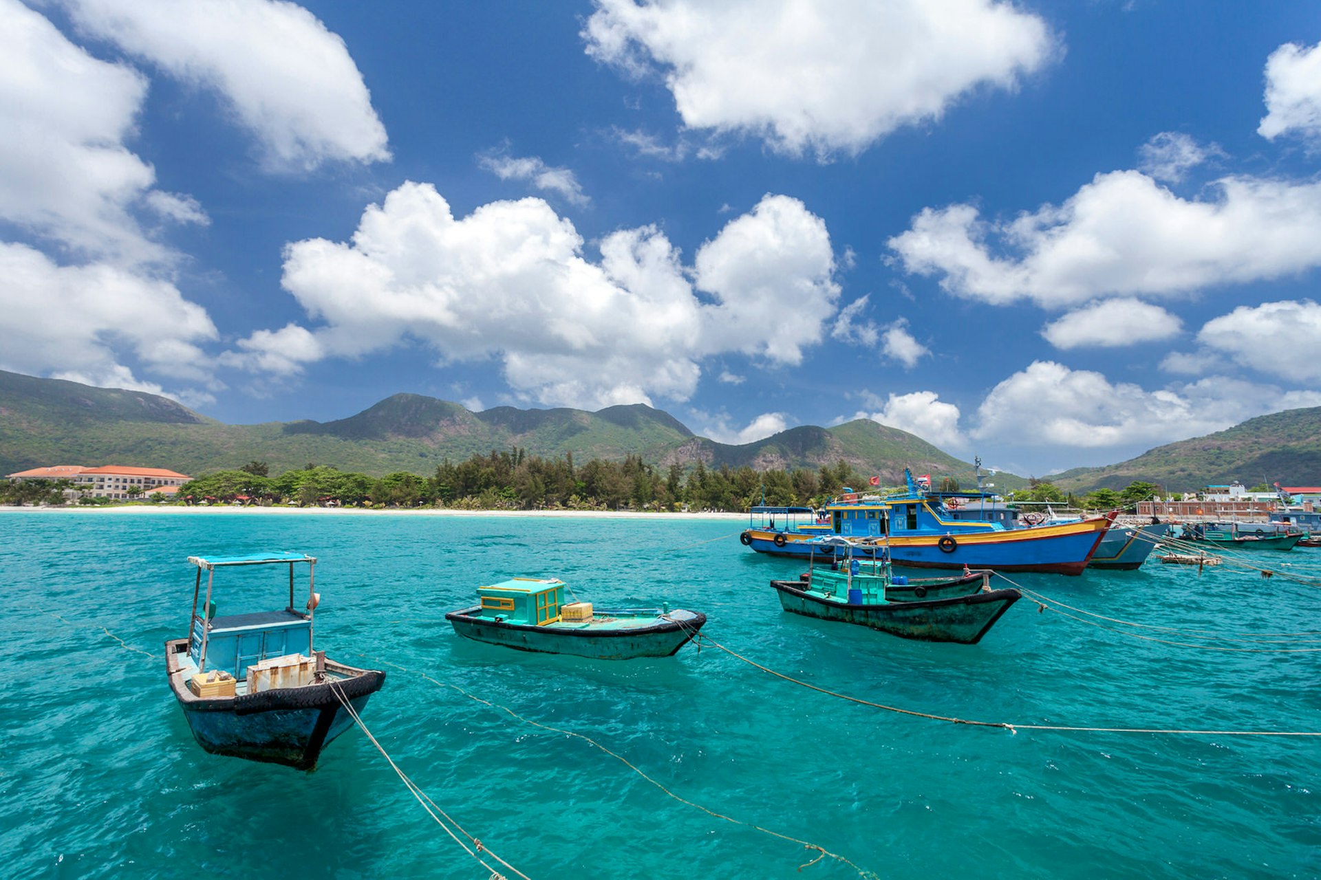 Vietnamese fishing boats on a tropical Con Dao Island. View from the pier in the direction of a beach with white sand.