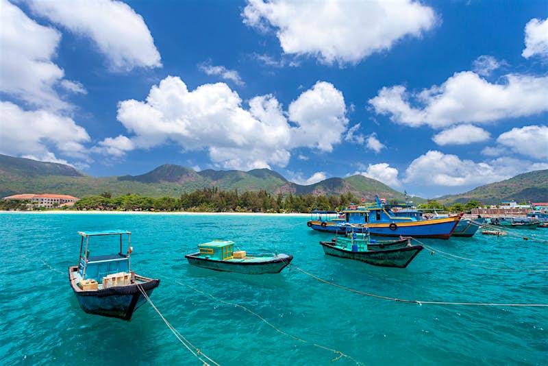 Vietnamese fishing boats on a tropical Con Dao Island. View from the pier in the direction of a beach with white sand.
