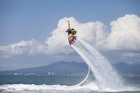 Features - Guy Airboarding Pacific Ocean, Mountains in Backgr