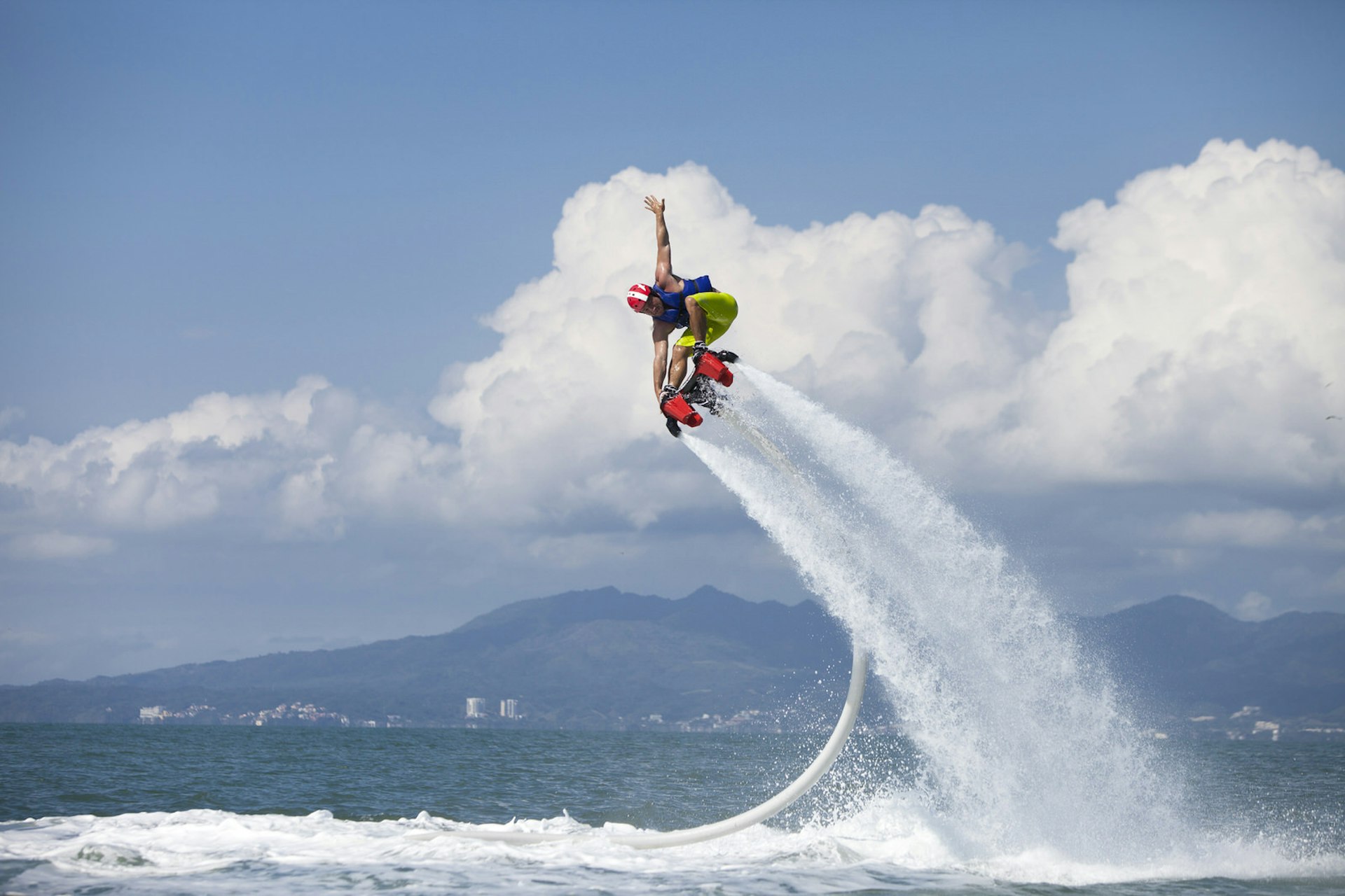 Guy Airboarding Pacific Ocean, Mountains in Backgr