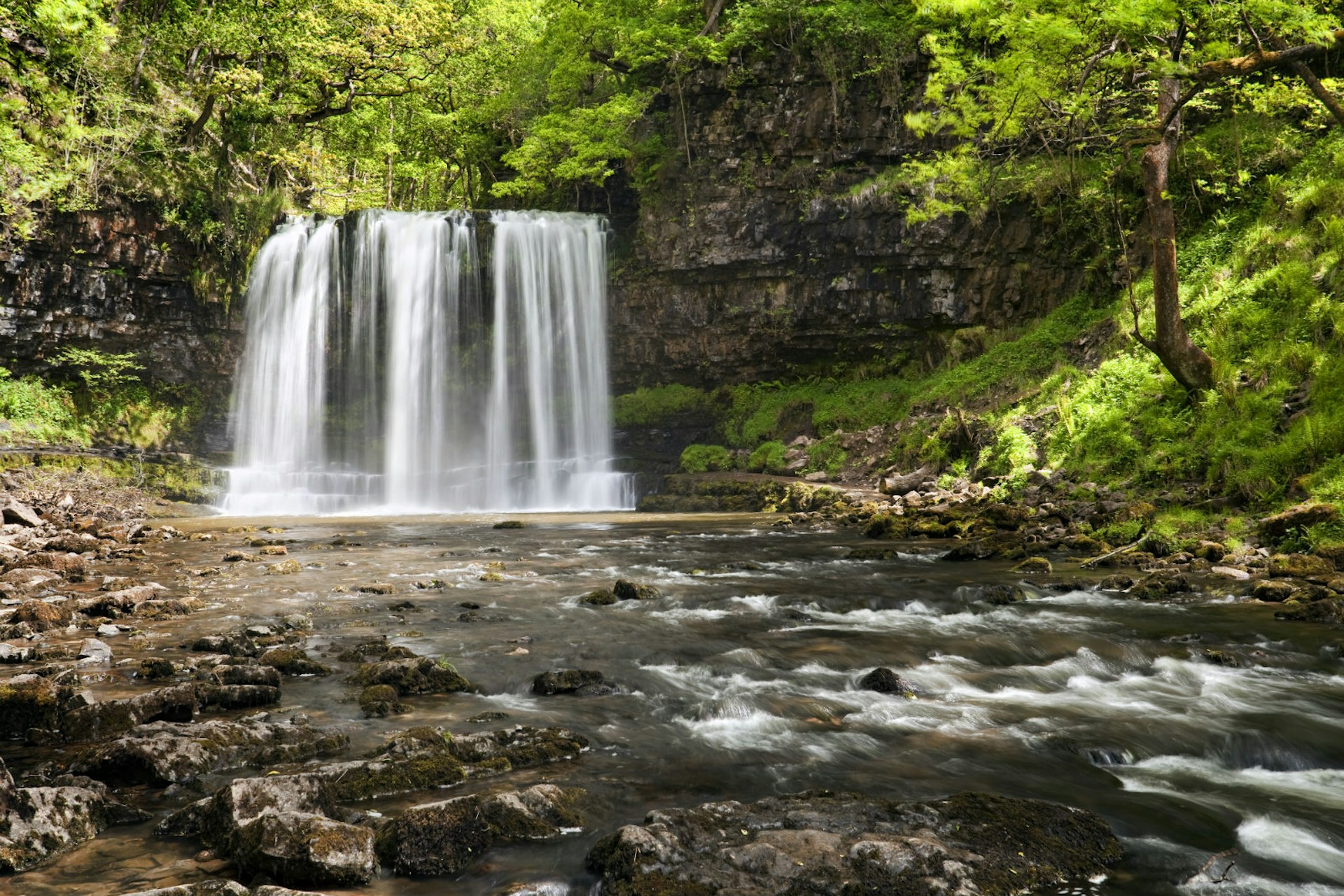 Visitors to the Brecon Beacons can walk behind the beautiful Sgwd-yr-Eira (the Snow Waterfall) © Martyn Ferry / Getty Images