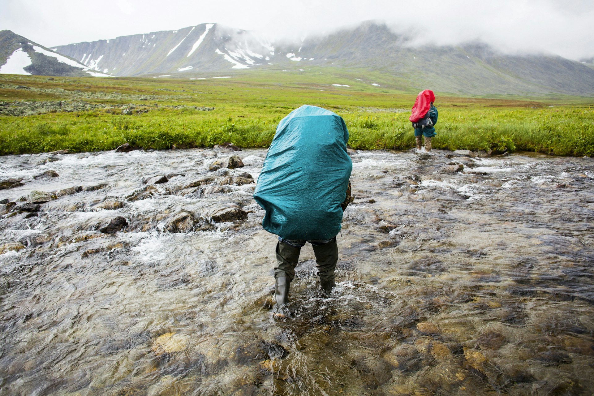 Backpackers crossing remote stream