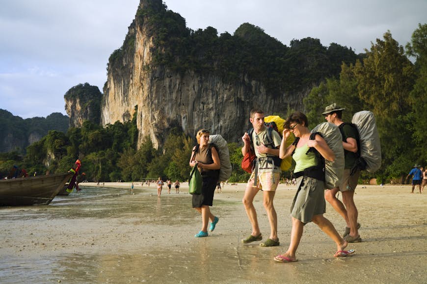 Turister som bär ryggsäckar på West Railay Beach (Hat Rai Leh West).  Railay, Krabi, Thailand
