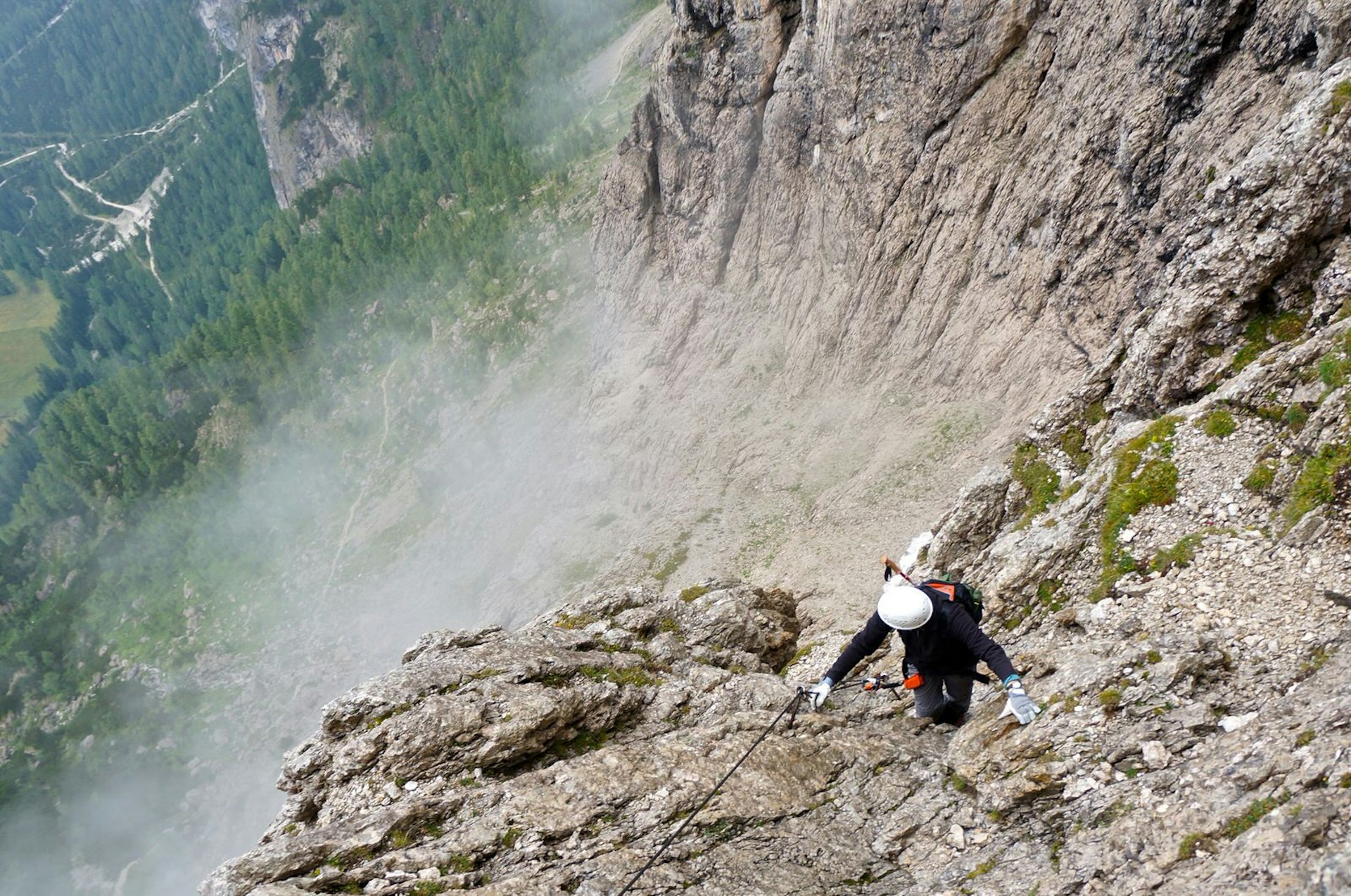 Climbing through the clouds up the Torre Exner pinnacle, with views of the Alta Badia valley below