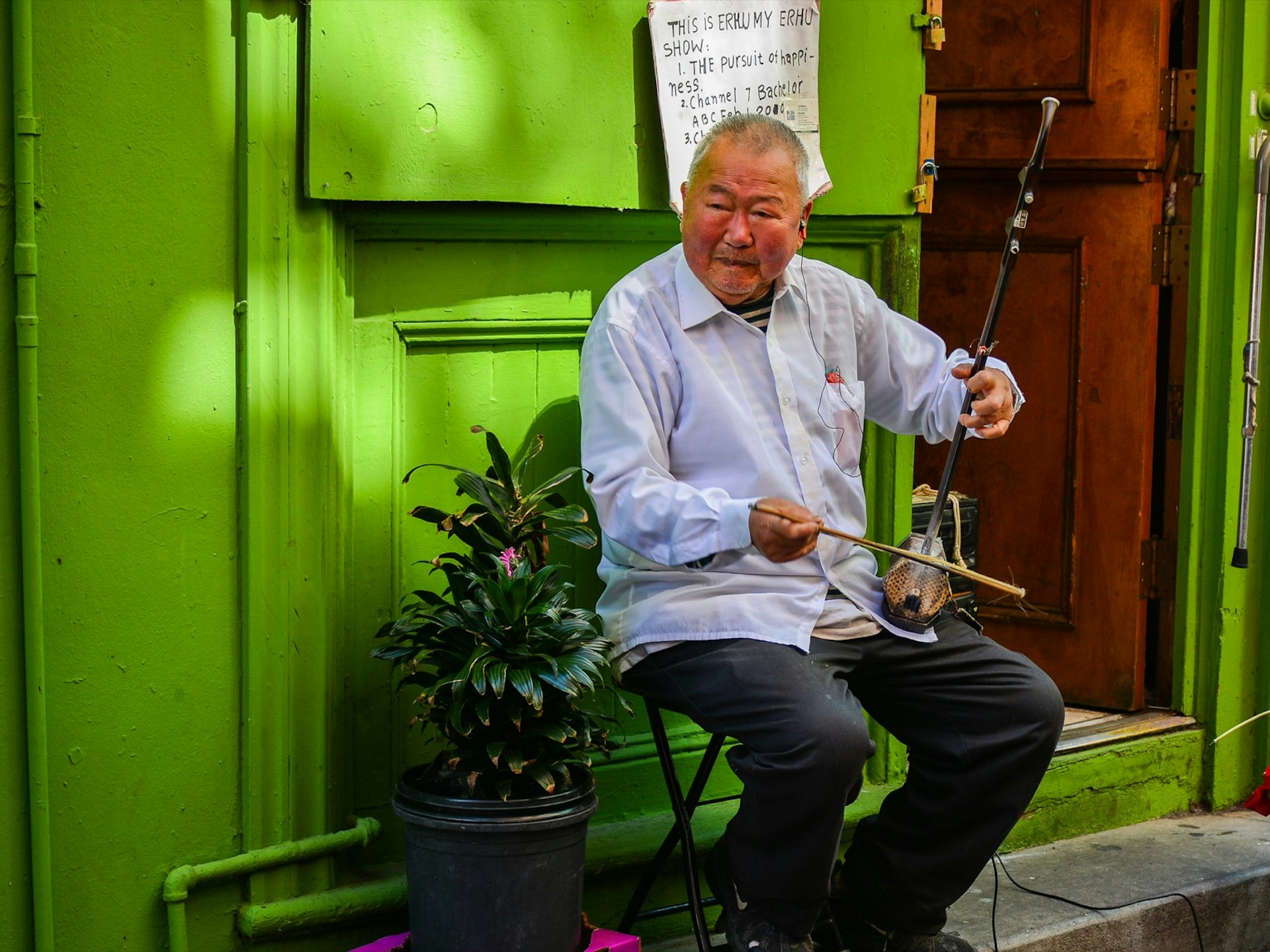 A man plays an instrument for tourists in a Chinatown Alleyway in San Francisco