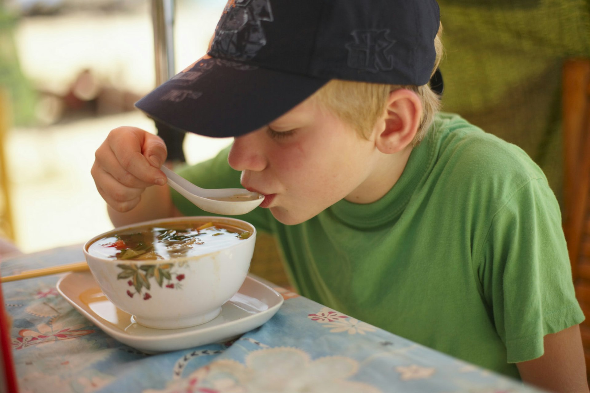 Child sips a bowl of soup © Johner Images / Getty Images