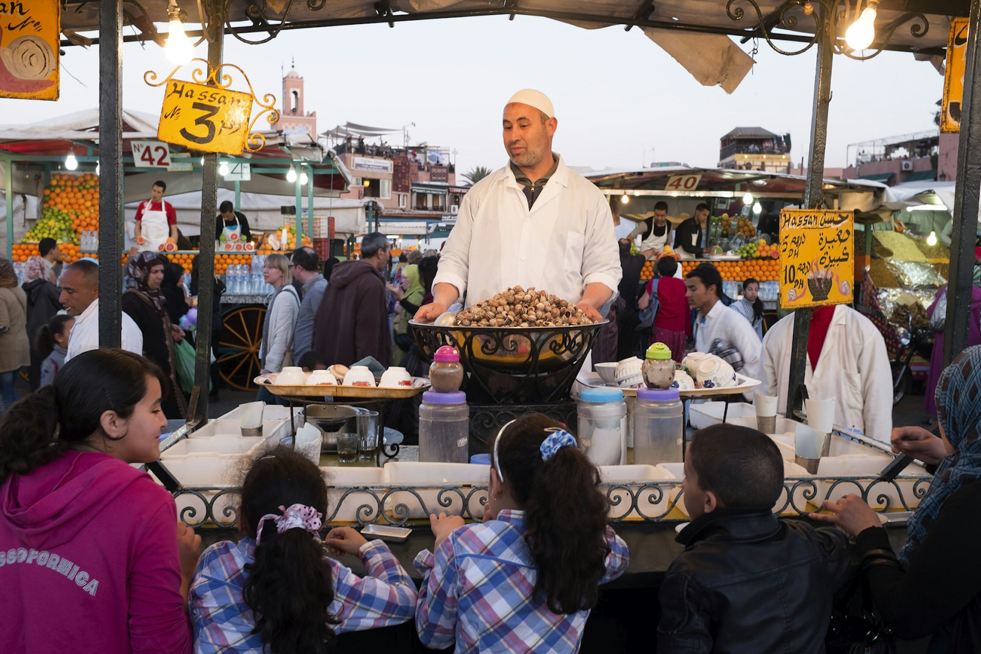 Children stand at stall where a man is selling snails © John Humble / Getty Images