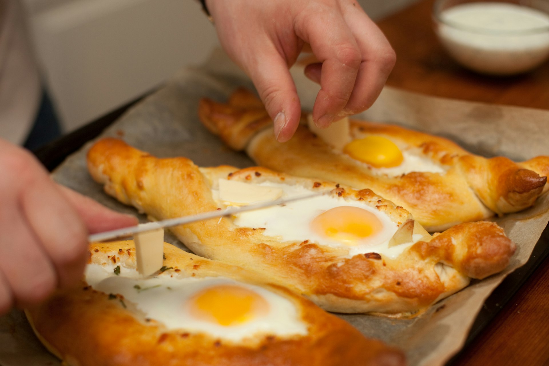 Three boat-shaped pastries with an egg baked on top