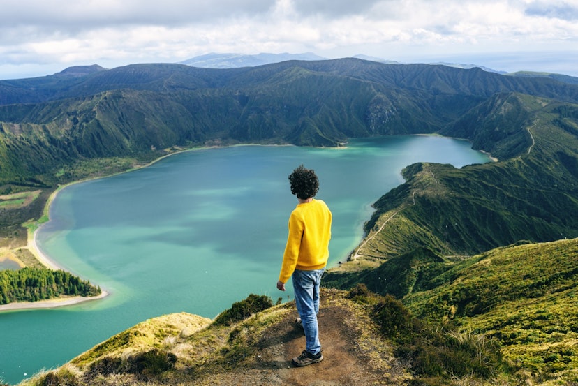 Azores Islands, San Miguel, Man looking at the Lake of Fire, seen from behind.