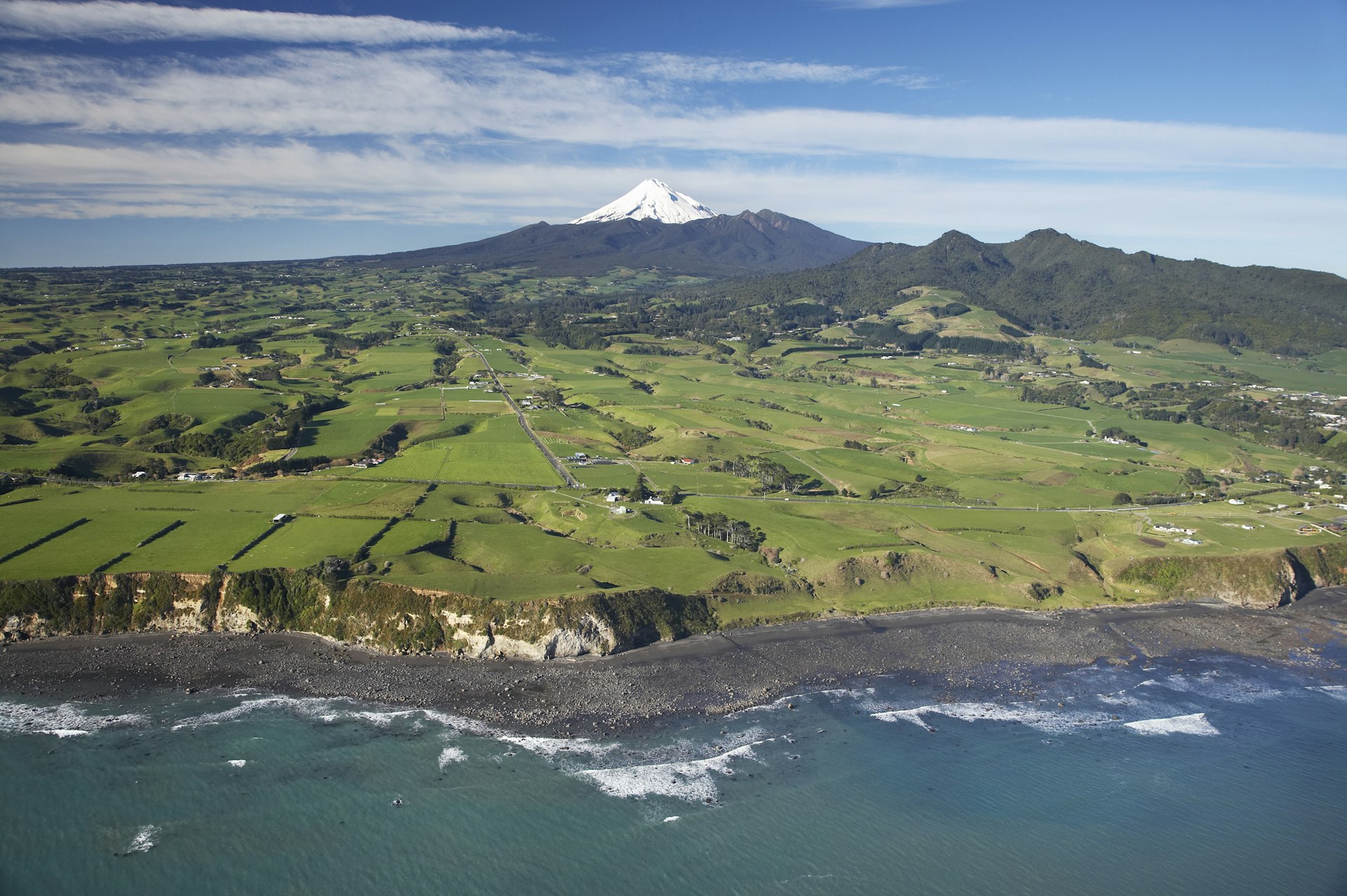 Aerial of Taranaki coastline near New Plymouth with farmland and Mt Taranaki/Mt Egmont in distance. David Wall Photo