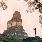 Features - A local man plays a flute at Tikal