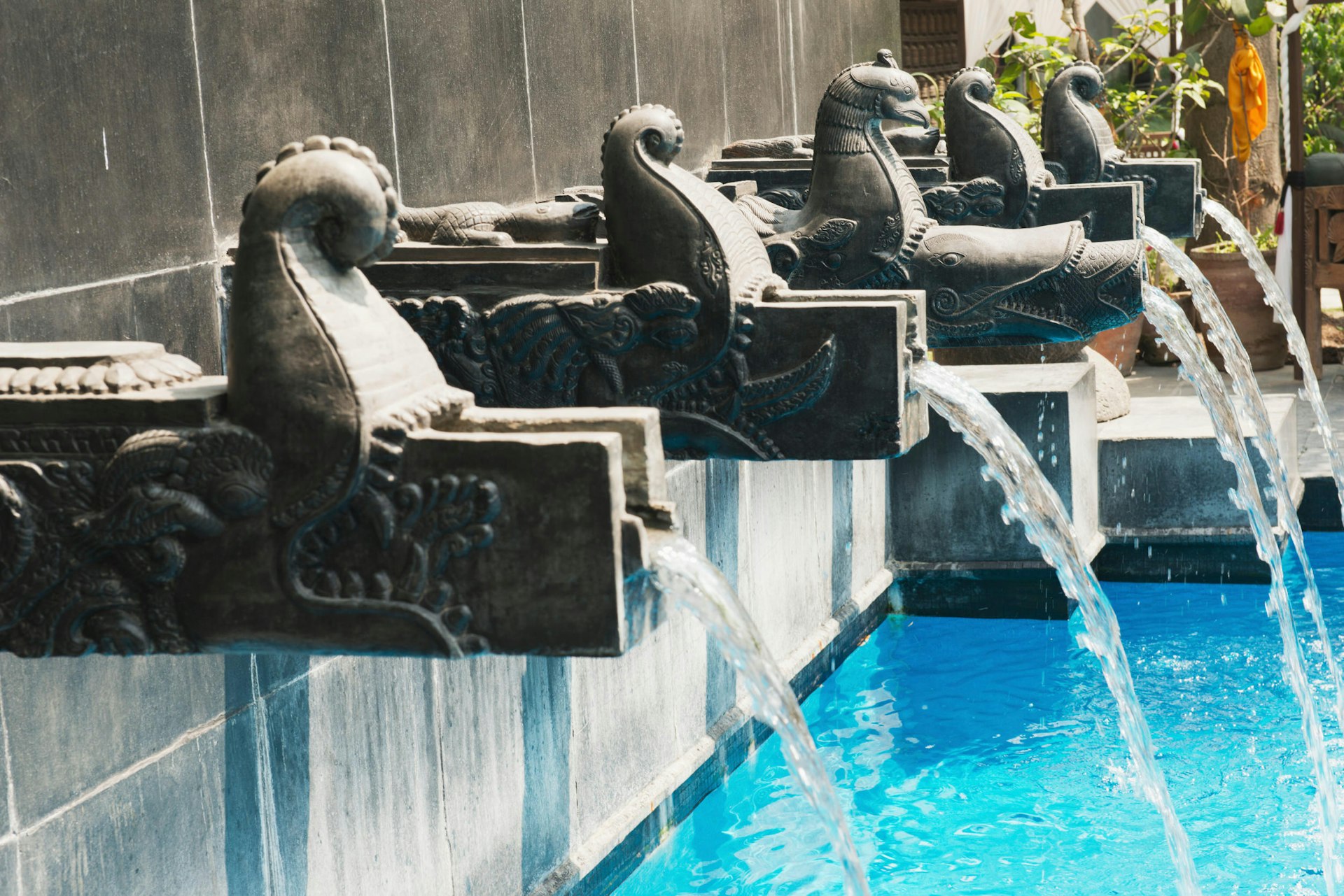 Traditional carved stone dhara (waterspouts) empty into the pool at Dwarika's Hotel © Heather Elton/Getty Images