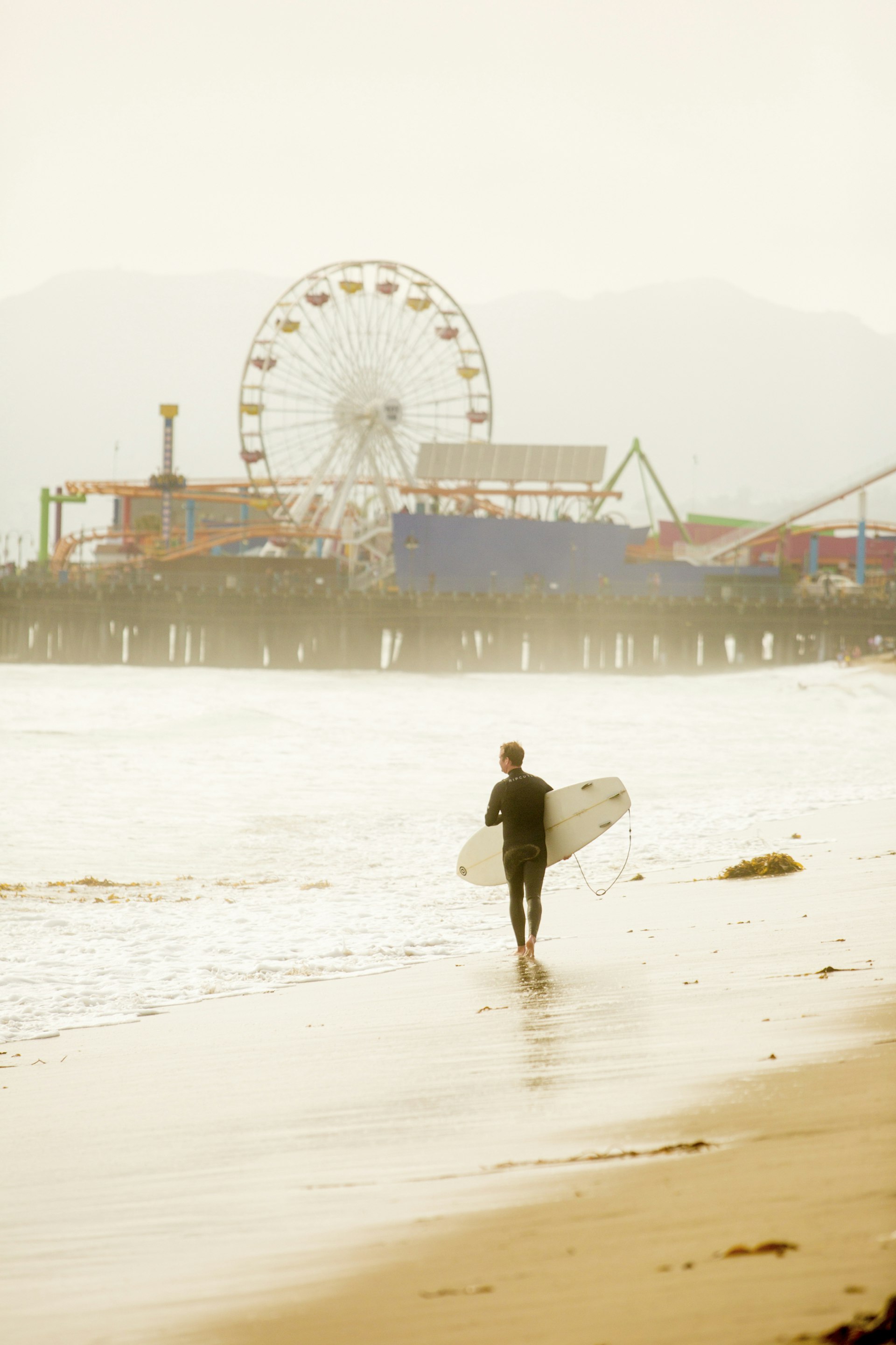 Surfer in Santa Monica, California by the Santa Monica pier.