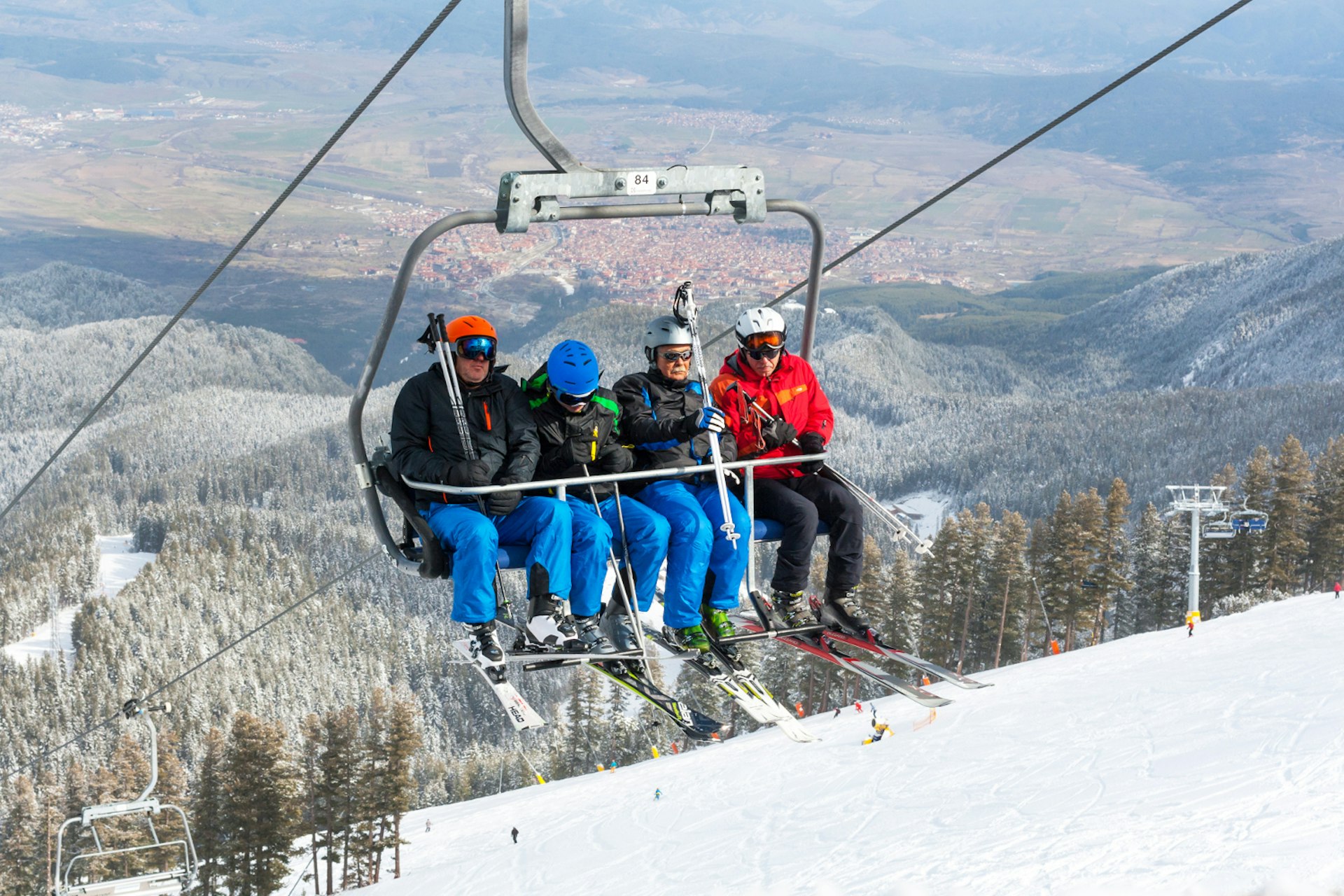 Bansko, Bulgaria - March 4, 2016: Ski resort Bansko, Bulgaria aerial view, skiers on lift, people skiing on slopes, town panorama