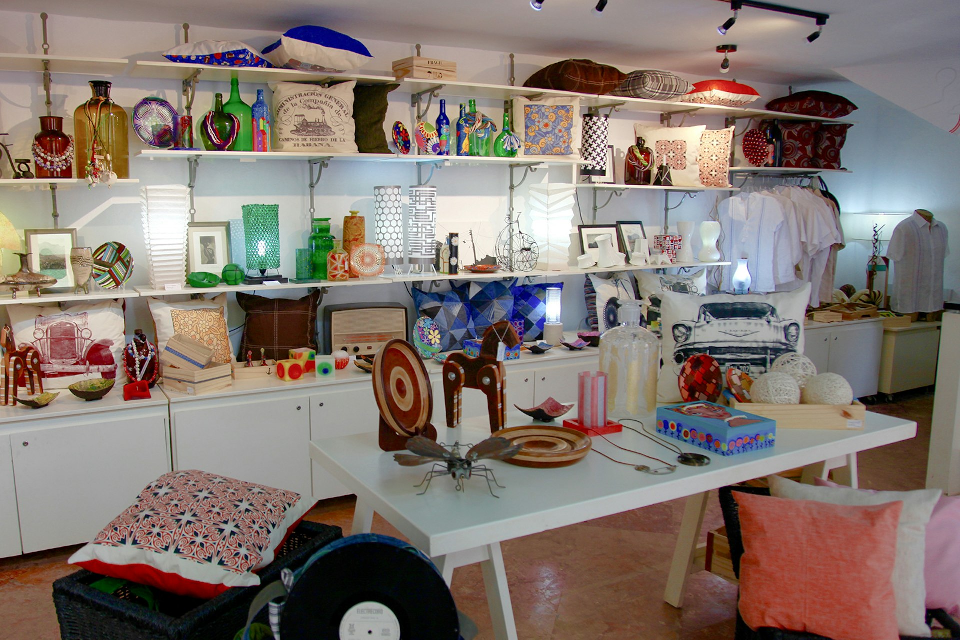 The interior of Piscolabis filled with wooden toys, plush multi-colored pillows and glass trinkets. Shopping local in Havana is getting easier.