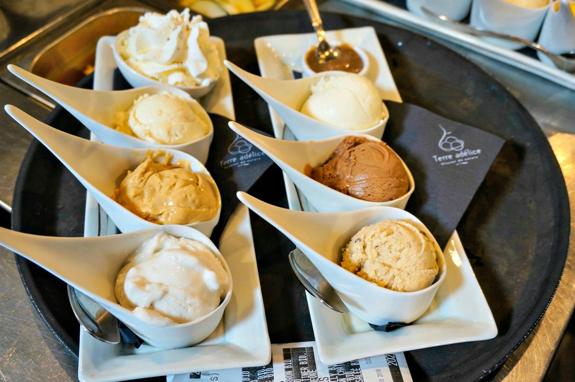 Each ice cream scoop is served in a single, white china spoon at Terre Adélice. Image © Monica Suma / Lonely Planet
