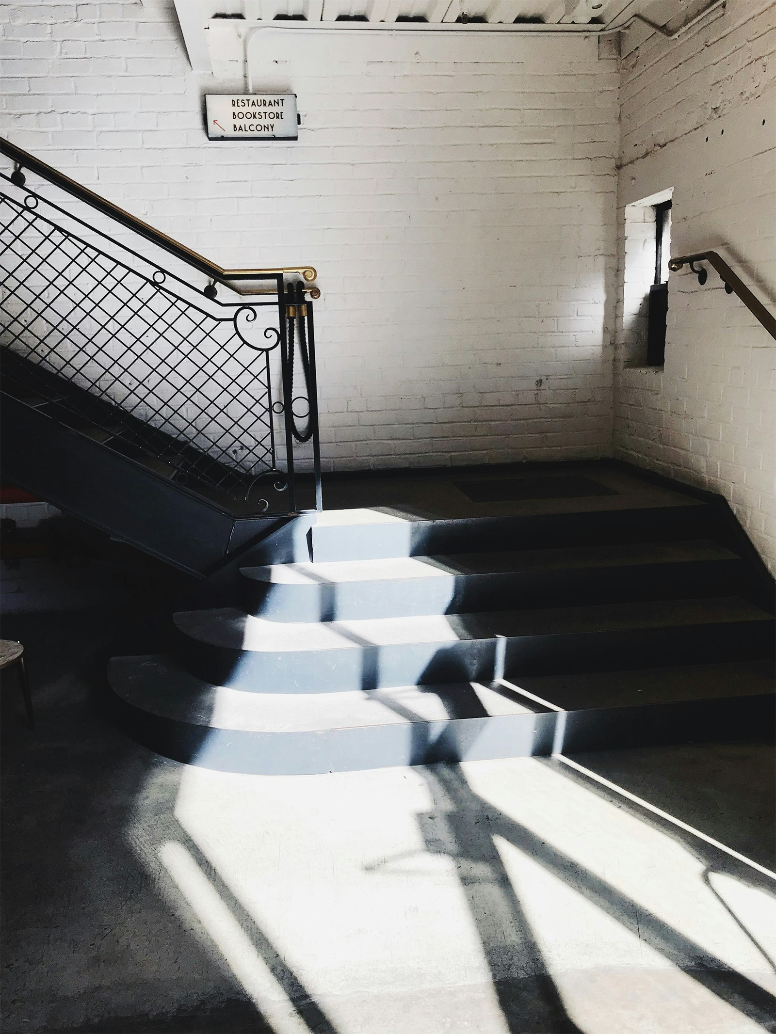 sunlit staircase at Metrograph, a theater on the Lower East Side