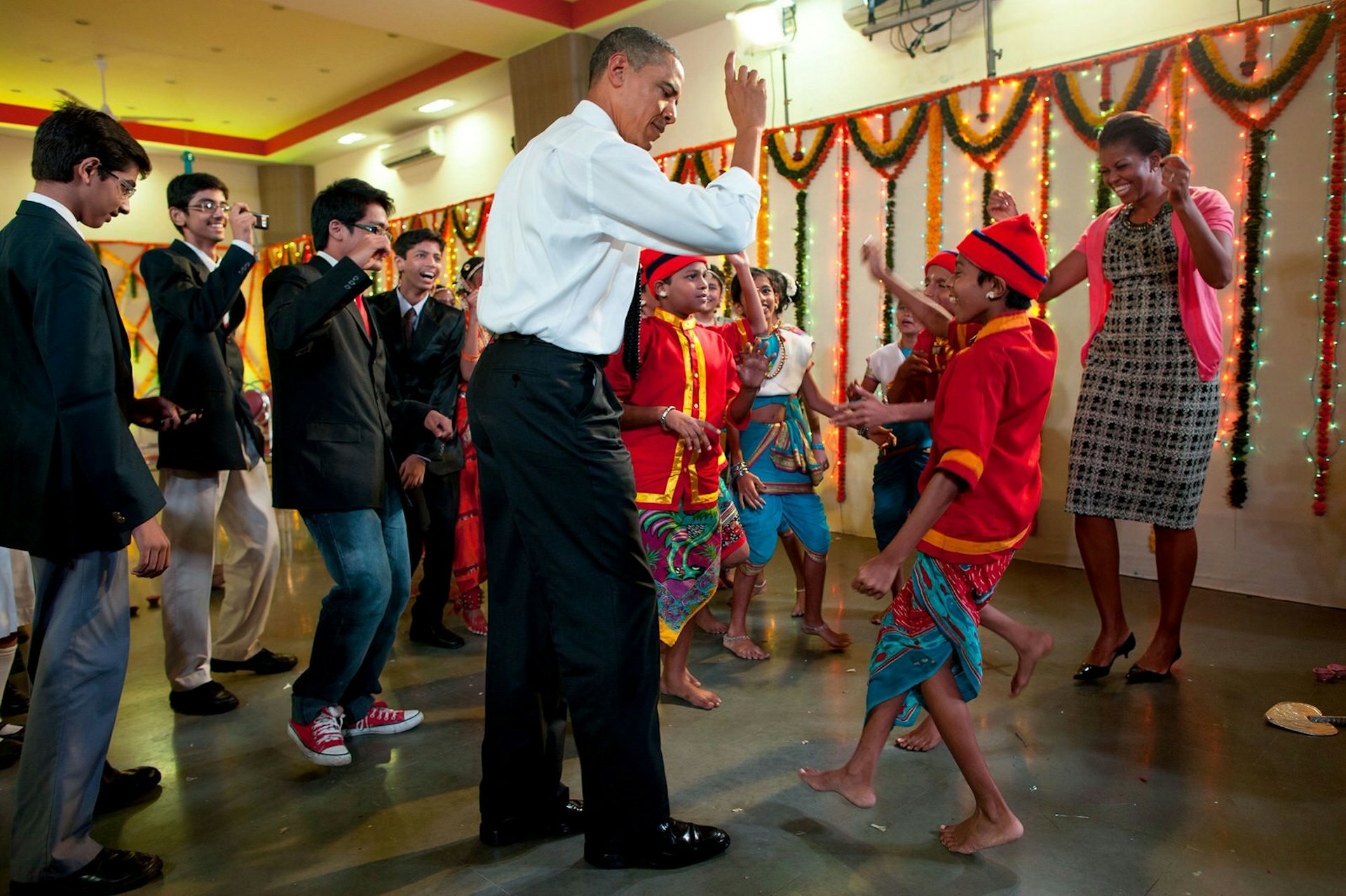 The president dancing with school children and the First Lady in Mumbai, India, Nov 7, 2010 © Pete Souza / Official White House Photo