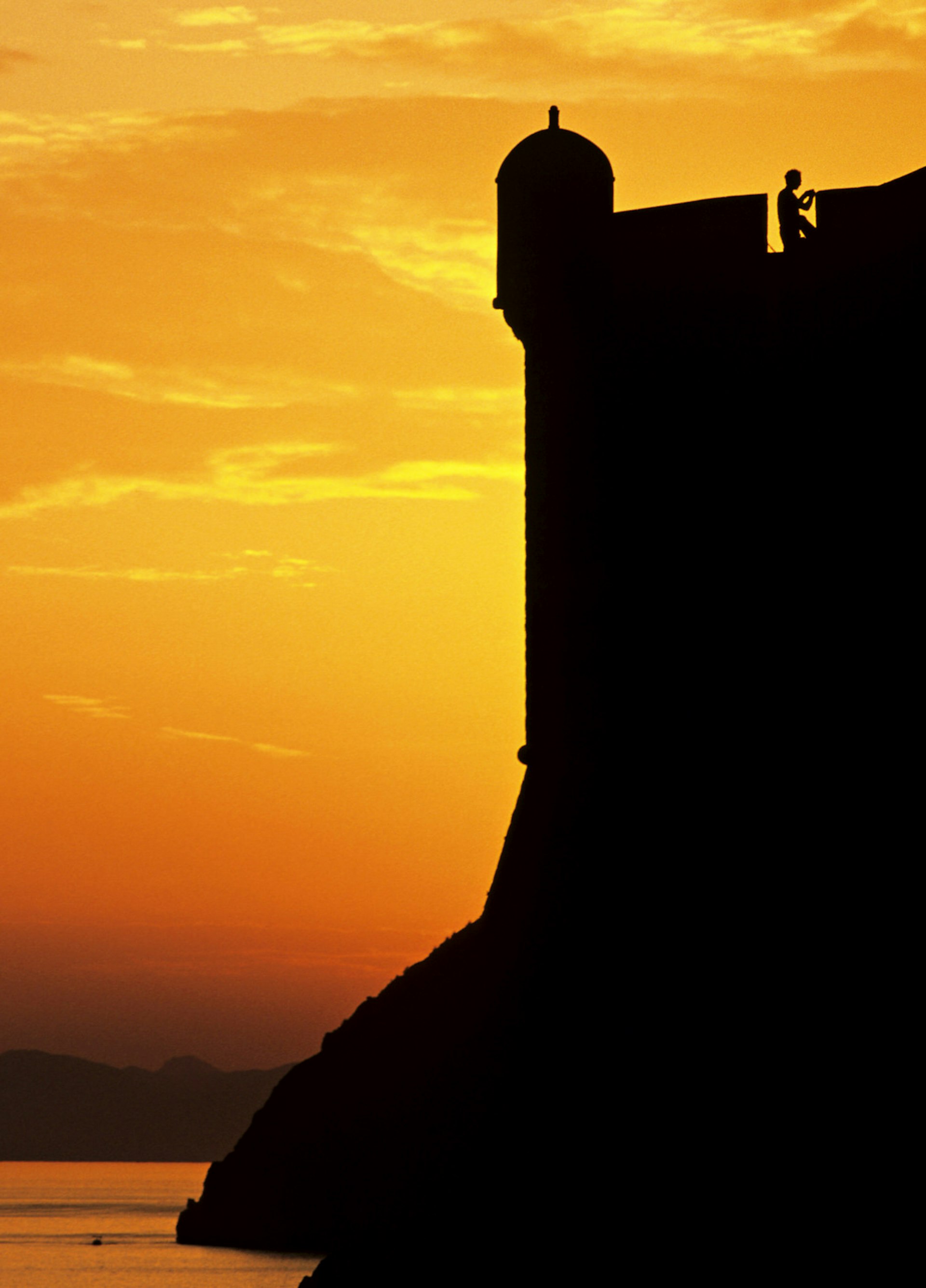 Dubrovnik fortifications silhouetted against a flaming sky 