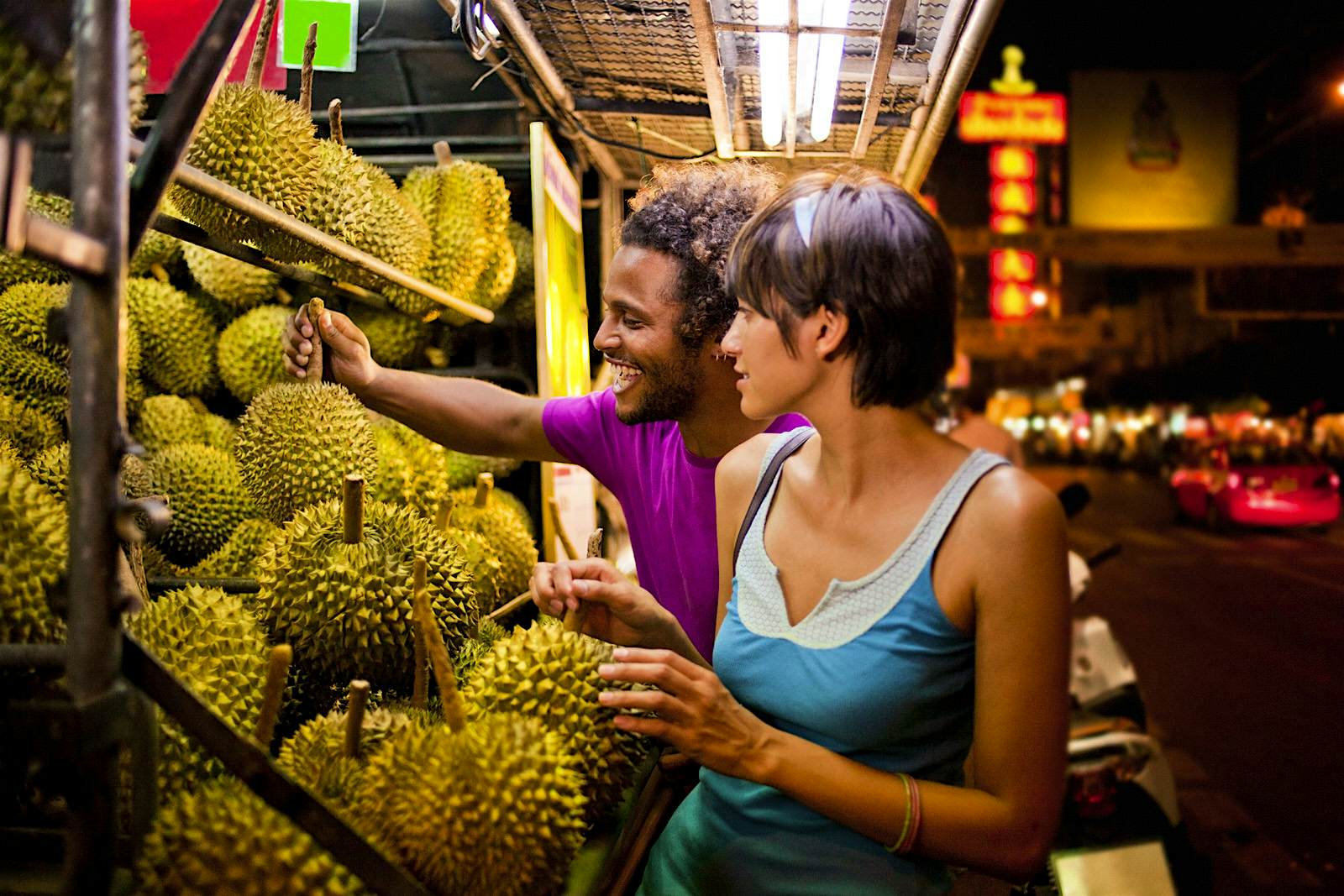 Features - Couple shopping at fruit stall A couple examine fruit at a stall
