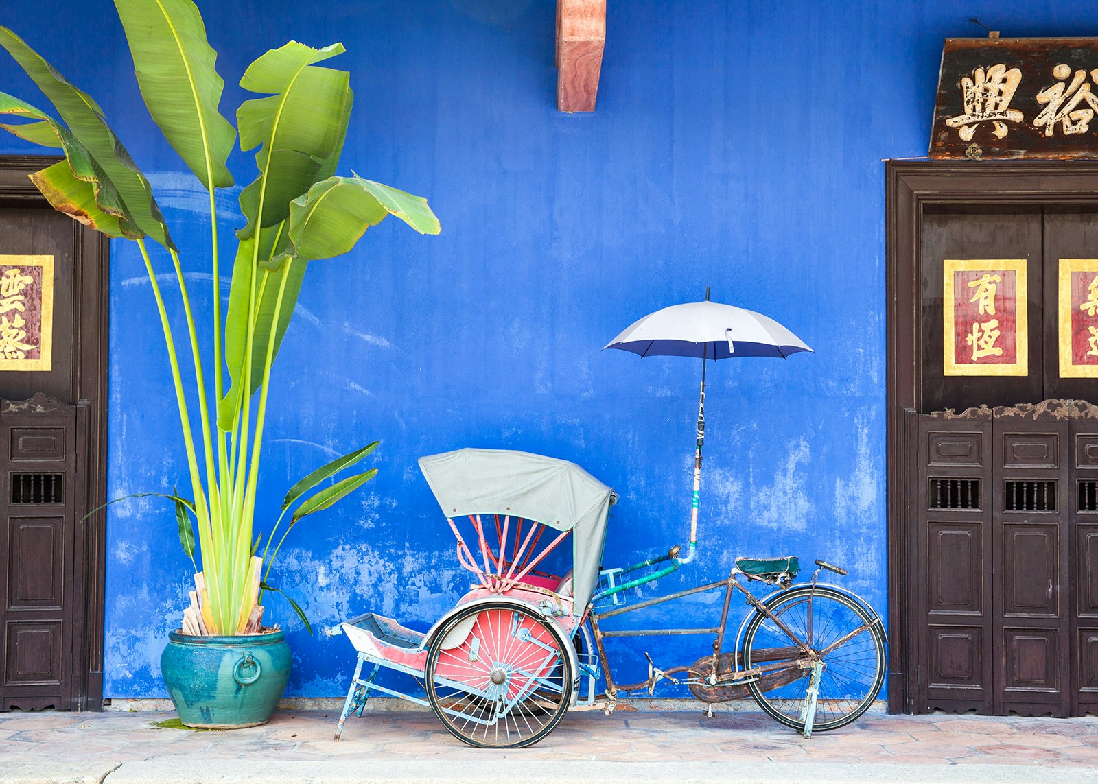 Old rickshaw tricycle near Fatt Tze Mansion or Blue Mansion, a famous oriental historical building in Georgetown, Malaysia © Elena Ermakova / Shutterstock