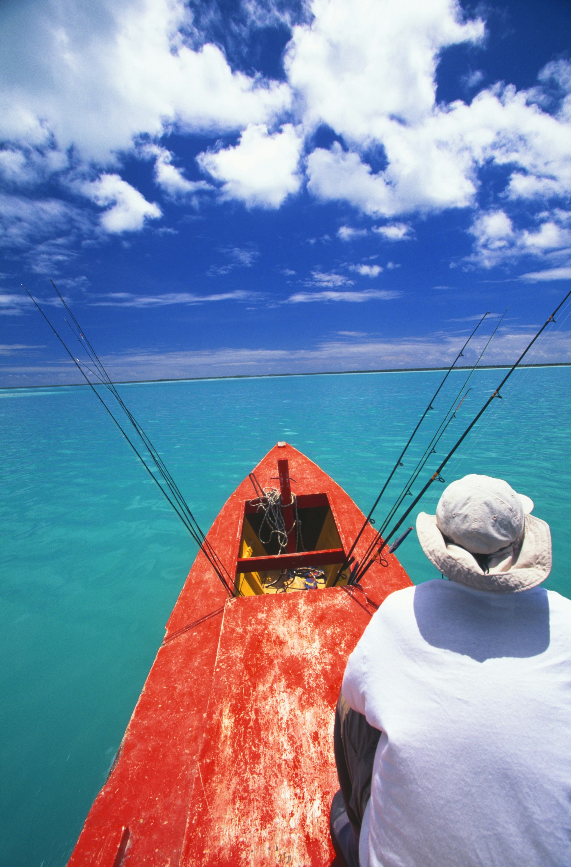 Features - Christmas Island, bone fishing from a red boat, man sits in front.