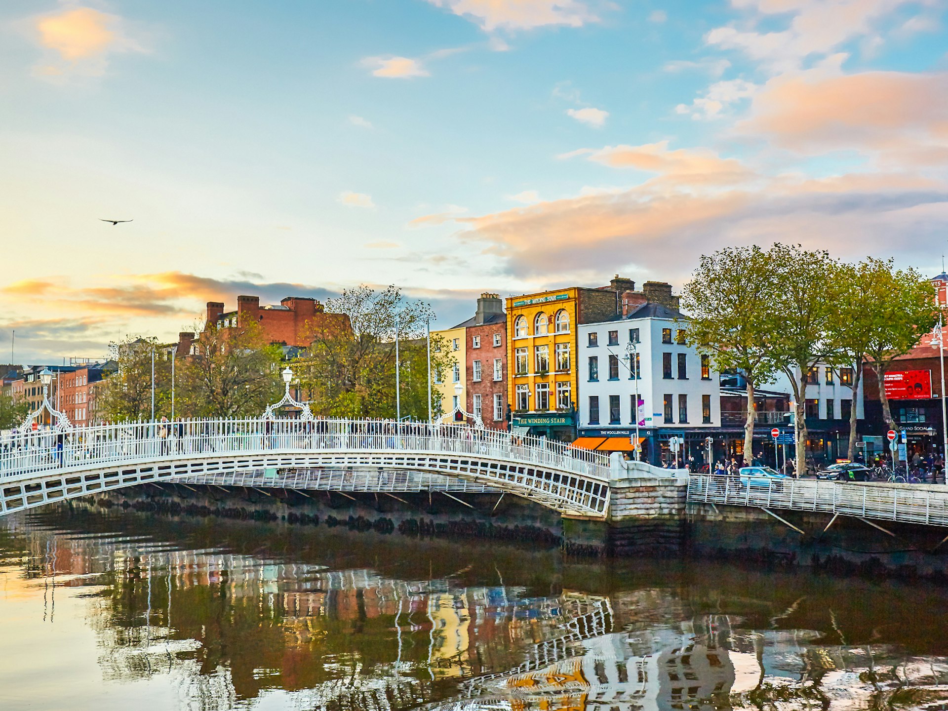 The Ha'penny Bridge over the River Liffey with colourful buildings lining the riverside