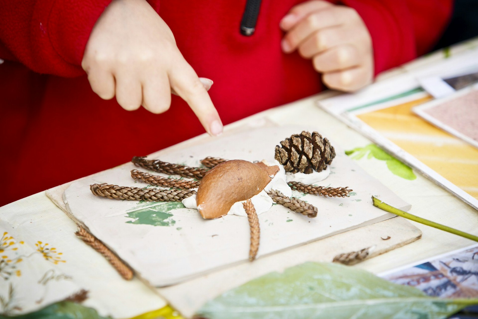 A child points at some art made from garden cliippings