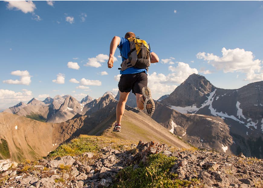En spårlöpare som kör längs åsen på ett berg © Ascent Xmedia / Getty Images