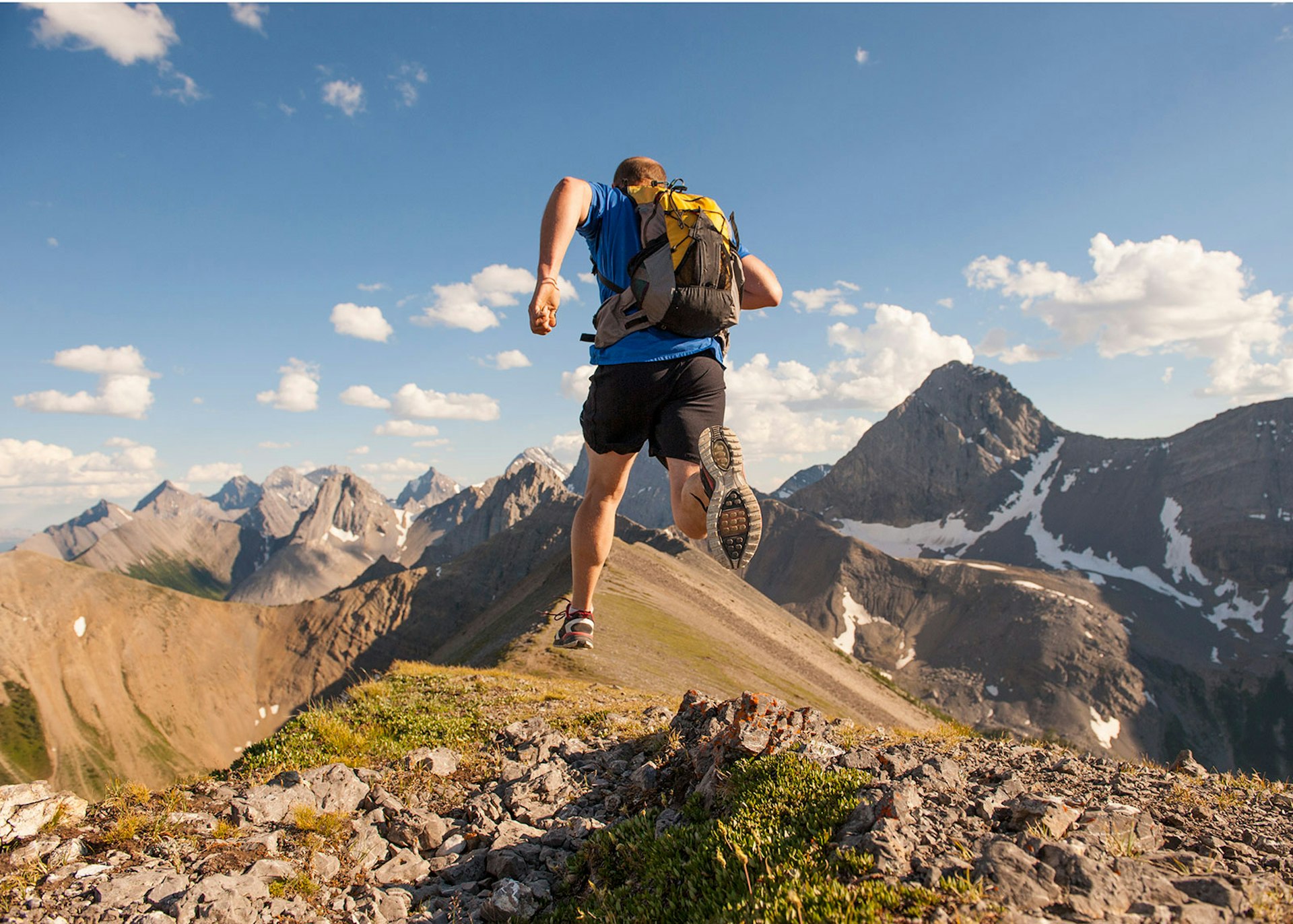A trail runner powering along the ridge of a mountain © Ascent Xmedia / Getty Images