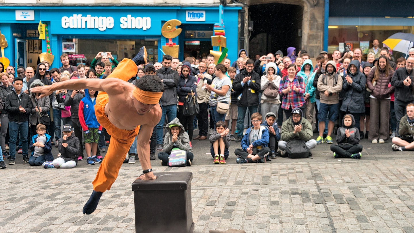Performers and people fill the streets during the Edinburgh Fringe © georgeclerk / Getty Images