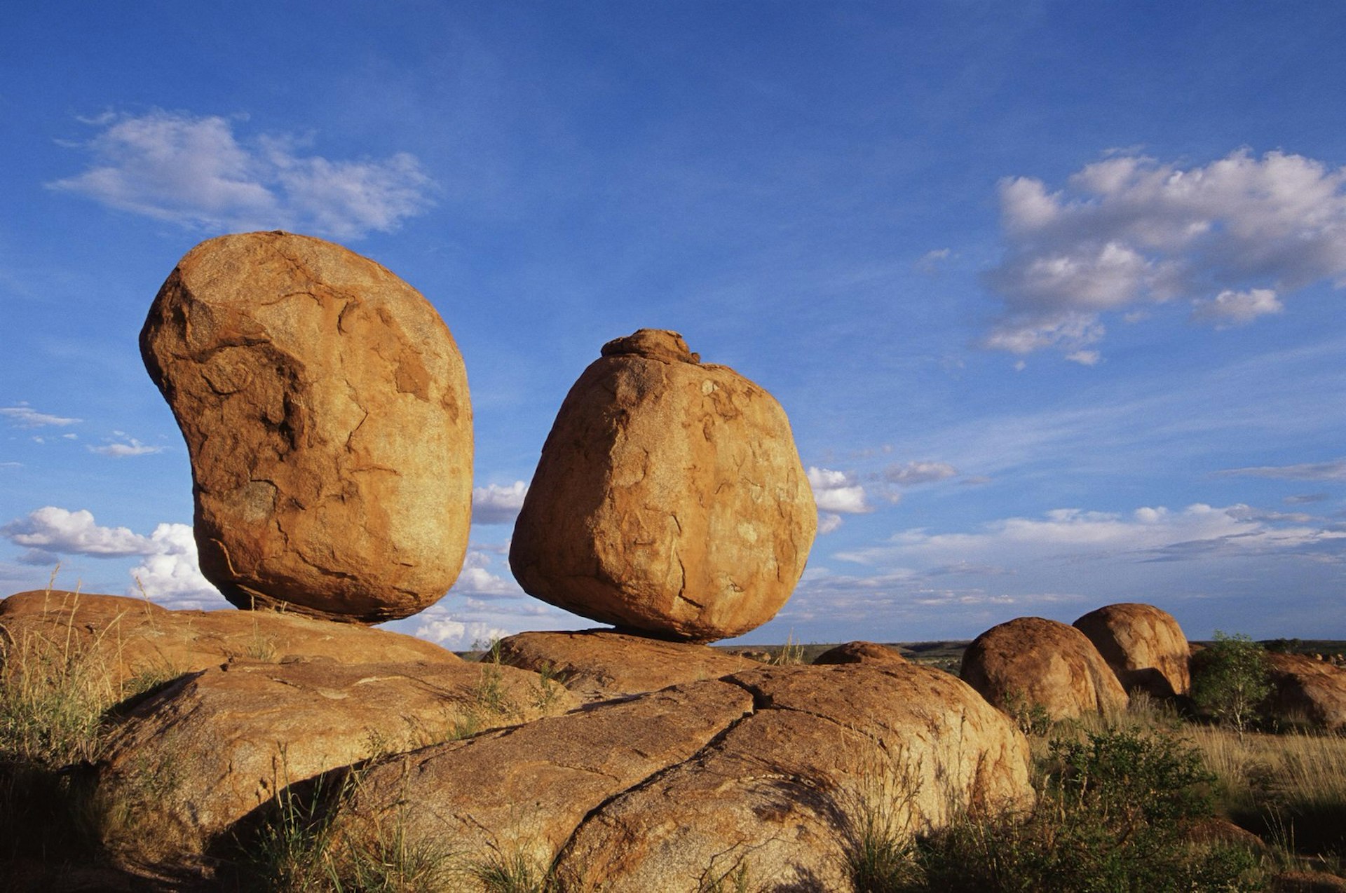 Two of the Devils Marbles balanced on a rocky ledge in the Australian outback © James Hager / robertharding / Getty Images