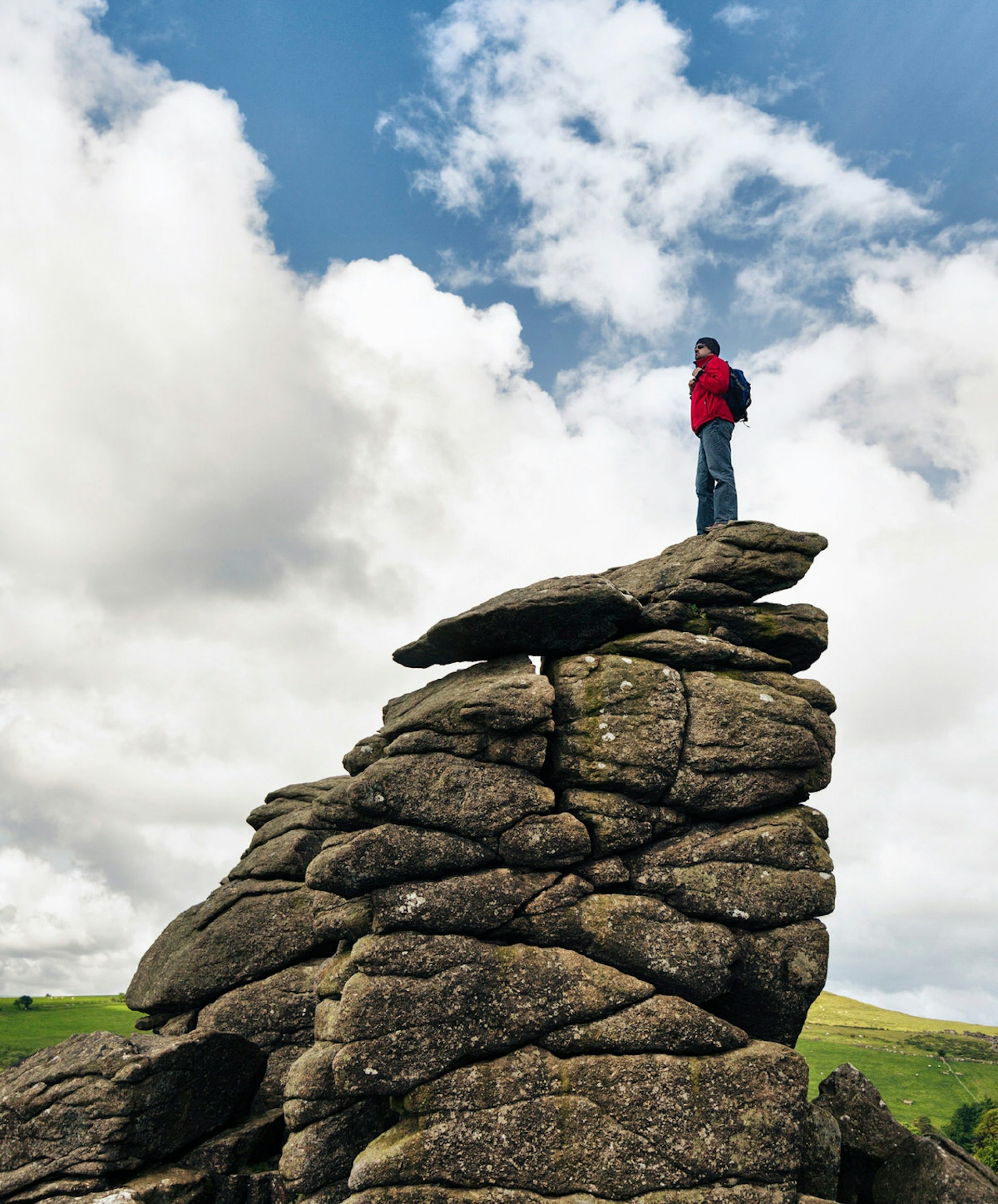 A hiker stands atop Hound Tor on Dartmoor. Devon is packed with great walking routes © Rich Legg / Getty Images 