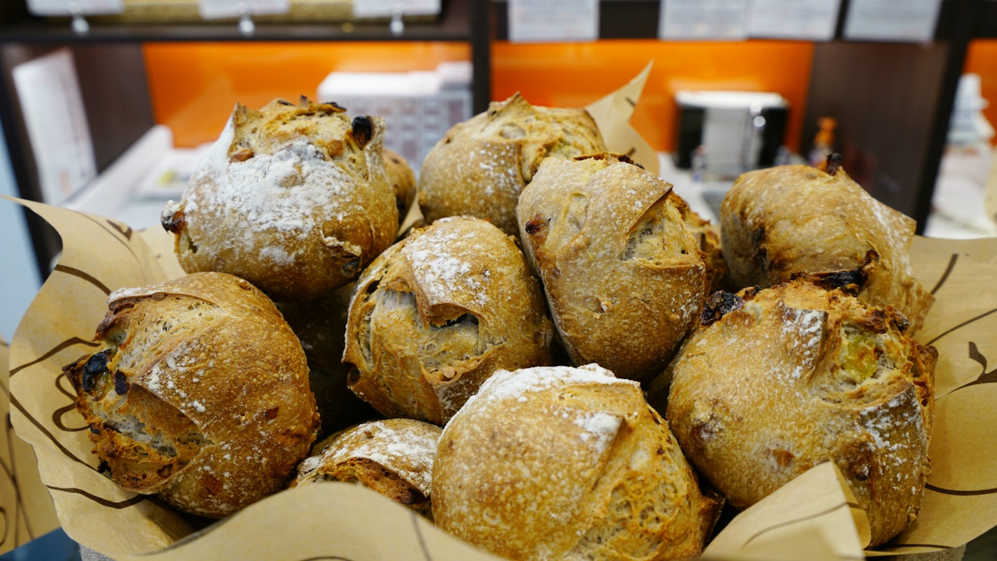 A basket of bread inside a Eric Kayser bakery