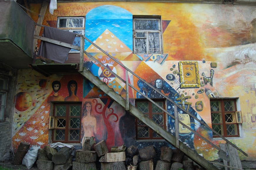 Ljusa väggmålningar som pryder väggarna i en byggnad i Užupis-distriktet