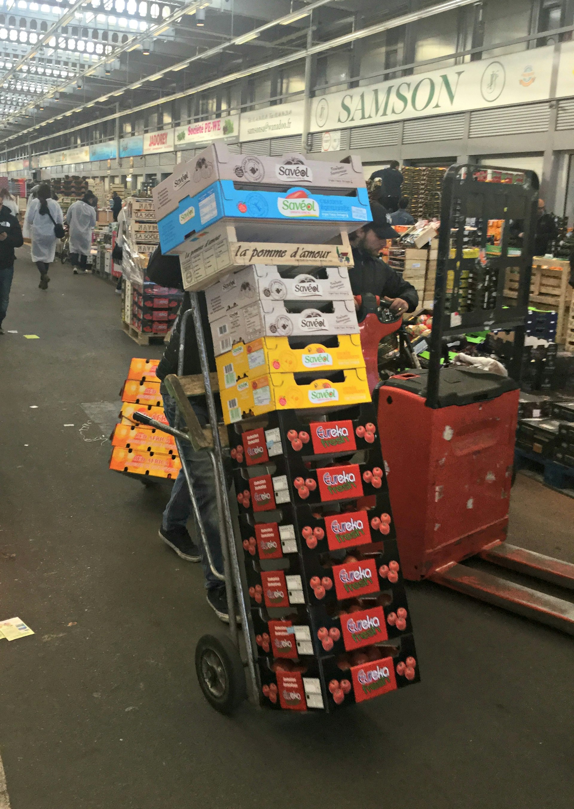 A worker pushes boxes of stacked vegetables through Rungis International Market 