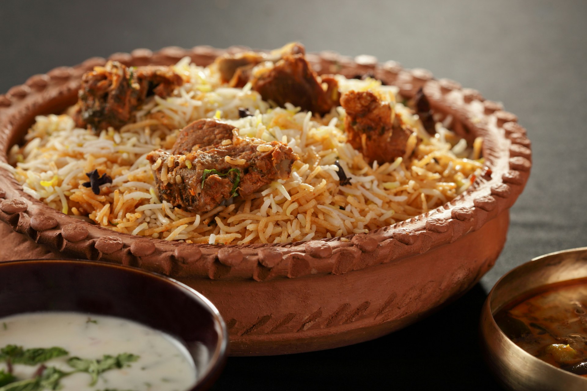 Mughal-inspired mutton biryani in an earthenware bowl 