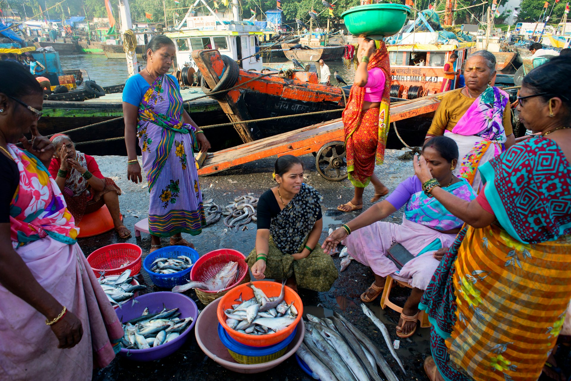 Koli fisherwomen haggling over baskets of fish at Sassoon Docks