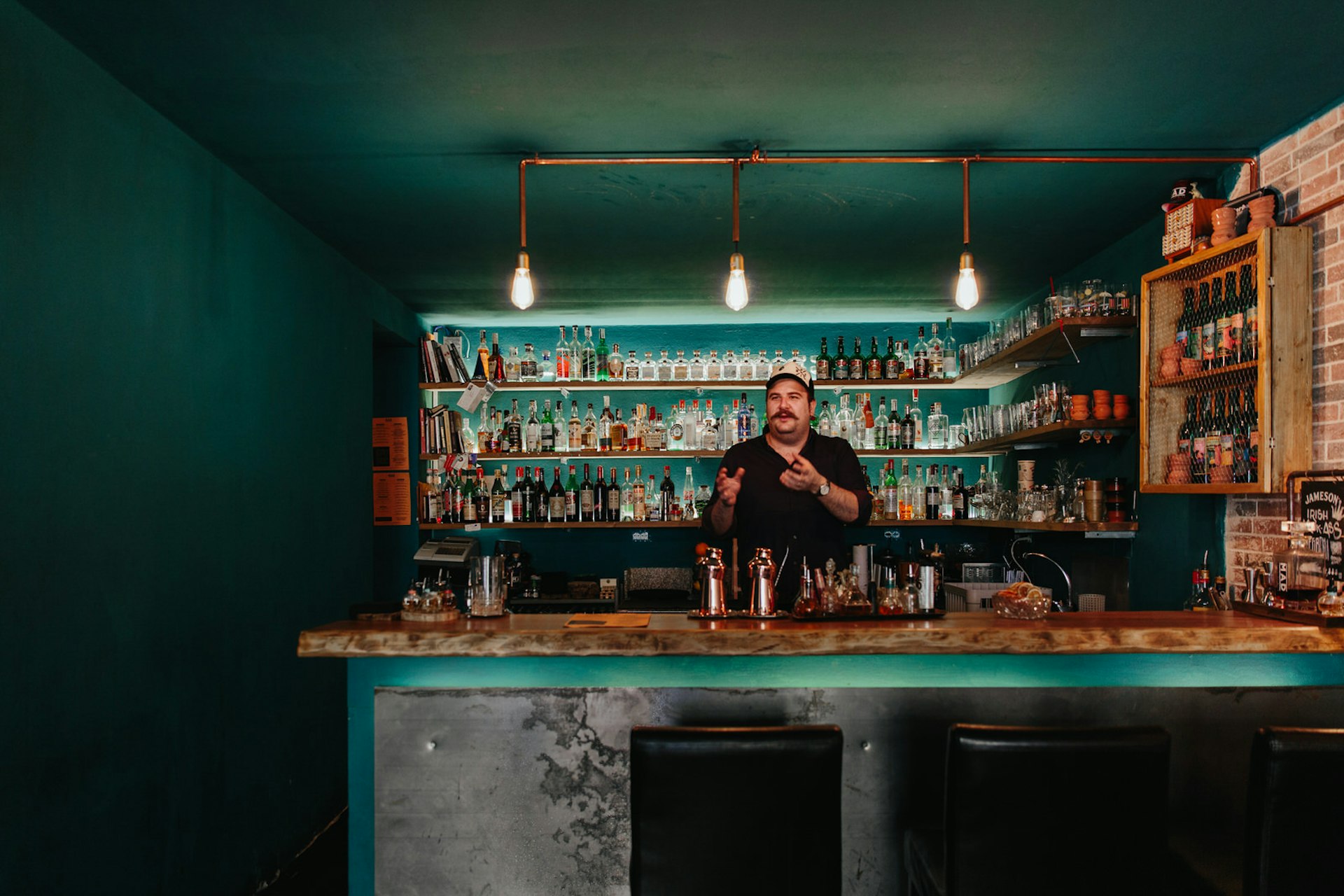 A bartender stands behind the bar at Mad Souls and Spirits, Florence, Italy © Marina Denisova